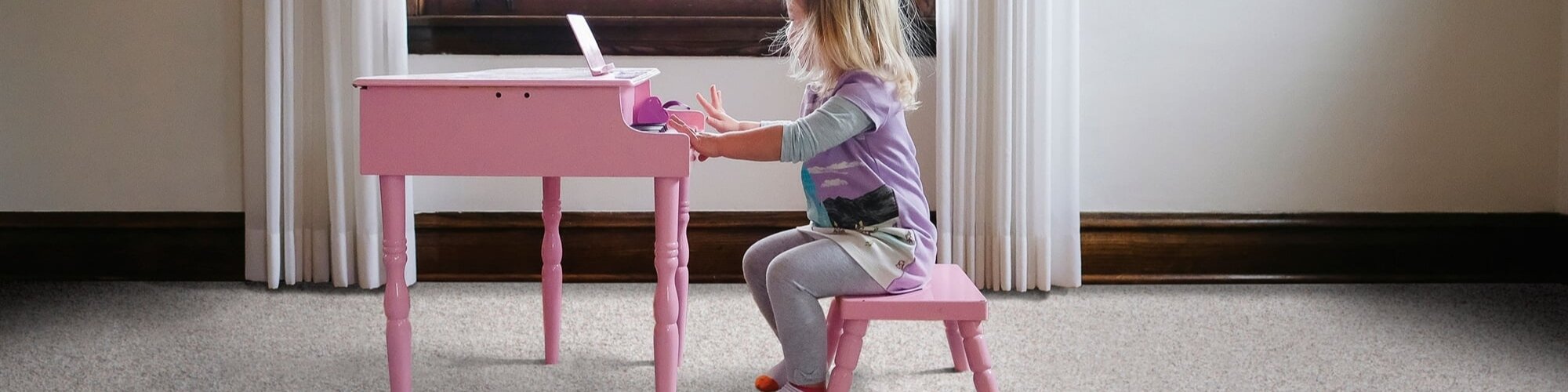 Toddler playing toy piano on SmartStrand Carpet